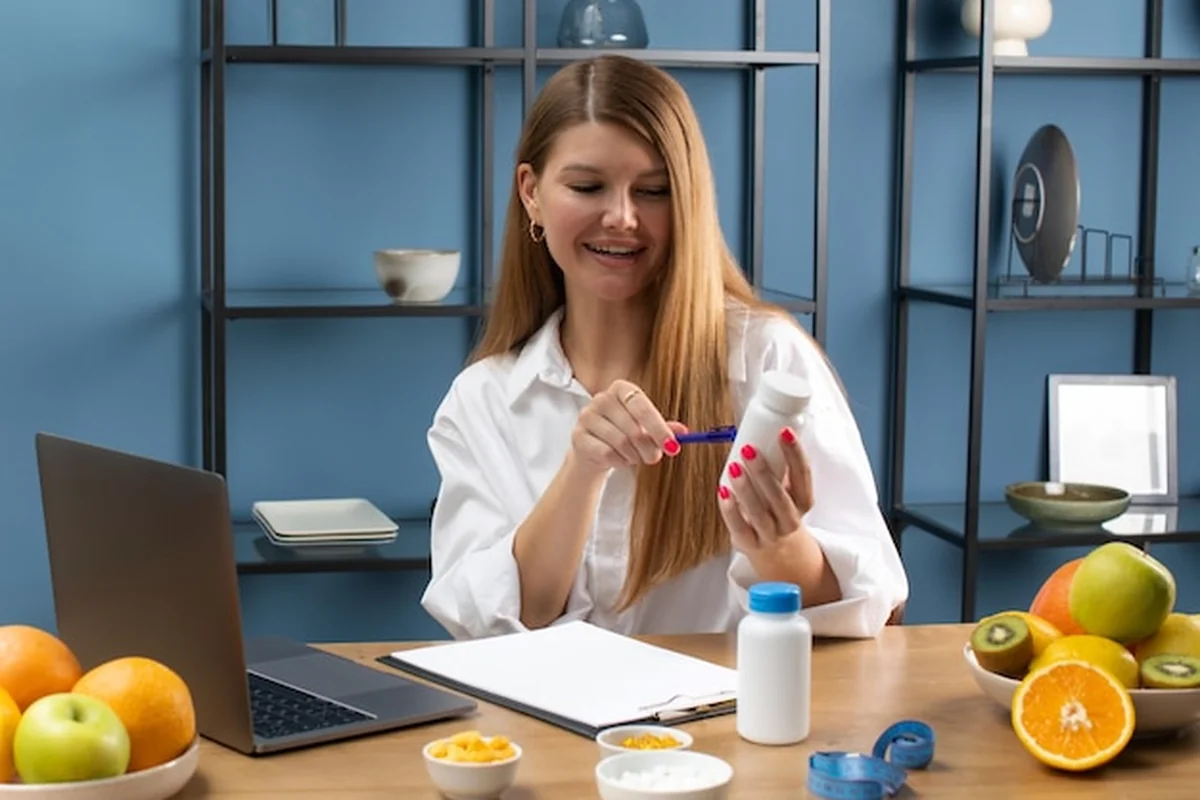 Lekarz pokazuje butelkę z suplementem pacjentowi przez wideokonferencję