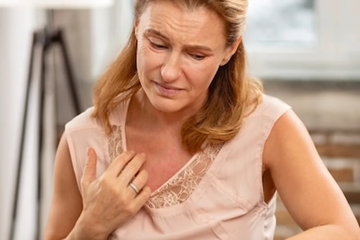 Dojrzała blondwłosa kobieta z alergią i wysypką na ciele