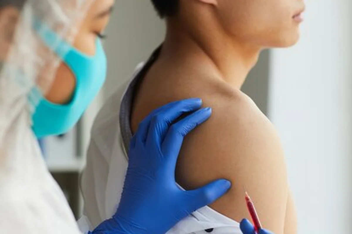 Pielęgniarka podająca szczepionkę pacjentowi w klinice