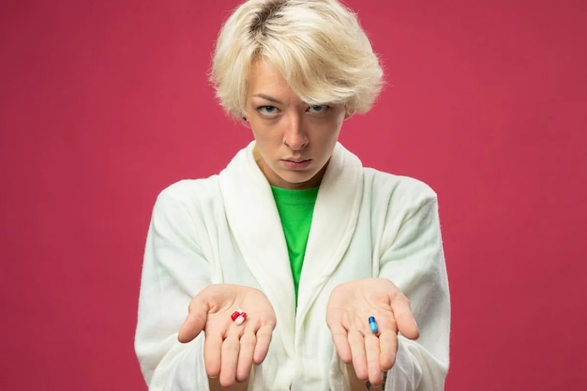 Kobieta z objawami anemii trzymająca pigułki na różowym tle