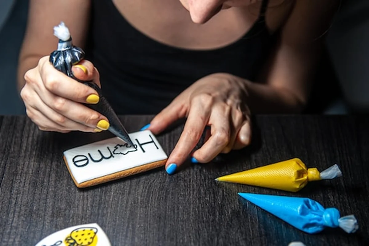 Kobieta w czerwonym fartuchu piecze patriotyczne pierniki