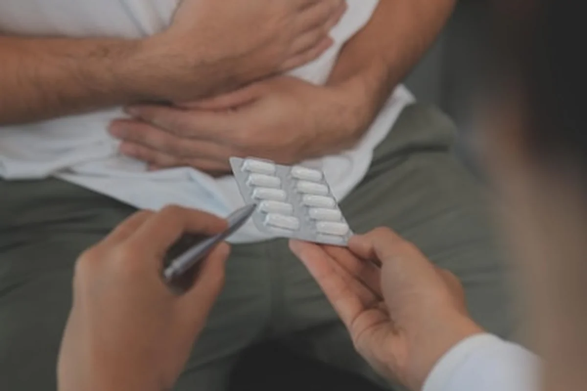 Mężczyzna trzymający brzuch z bólem w domu