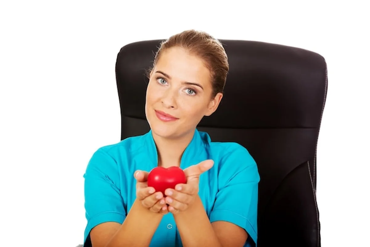 Lekarz trzymający model serca na białym tle